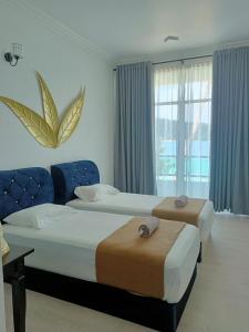 a hotel room with two beds and a window at Perhentian Bay Chalet in Perhentian Island