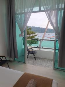 a bedroom with a large window with a view of the ocean at Perhentian Bay Chalet in Perhentian Island