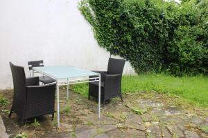 une table en verre et des chaises dans une cour dans l'établissement Large Garden Apartment on Golders Green High Road, à Londres