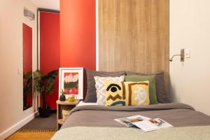 a bedroom with a bed with an orange wall at Unite Students - Chalmers Street - The Meadows in Edinburgh +6 photos