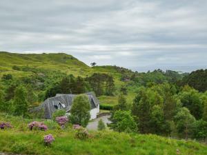 ein Haus mitten auf einem Feld mit Blumen in der Unterkunft 5 Bed in Roshven CA231 in Glenuig