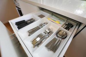 a drawer filled with silver utensils in a refrigerator at Satin Bower Cottage in Eagle Heights +30 photos