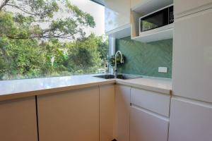 cocina con fregadero y ventana en Satin Bower Cottage en Eagle Heights