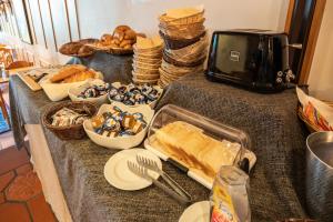 einen Tisch mit Brot und Gebäck sowie einen Toaster in der Unterkunft Hotel des Alpes in Flims