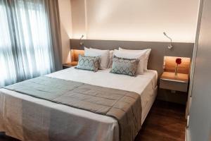 a bedroom with a large bed with pillows at Quality Porto Alegre in Porto Alegre
