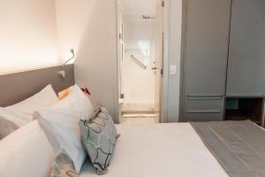 a bedroom with a bed with white sheets and pillows at Quality Porto Alegre in Porto Alegre