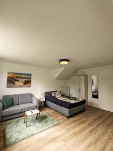 a living room with a bed and a couch at Apartmenthaus am Park in Wilhelmshaven