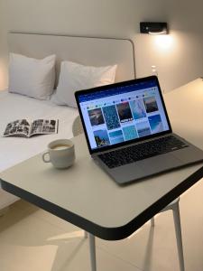 un ordinateur portable assis sur un bureau à côté d'un lit dans l'établissement Ultramarinn Hotel, à Odessa