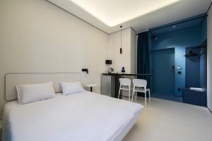 - une chambre avec un lit blanc et une table dans l'établissement Ultramarinn Hotel, à Odessa