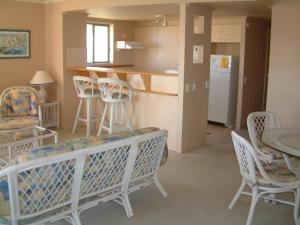 a living room with a table and chairs and a kitchen at Diamond Sands Resort in Gold Coast