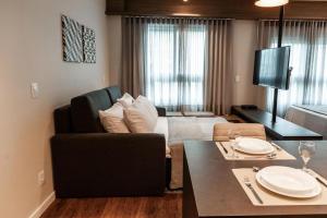 a living room with a bed and a dining table at Quality Porto Alegre in Porto Alegre