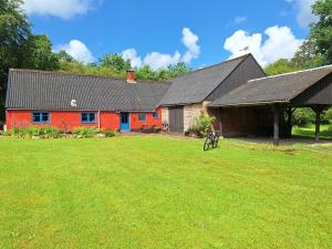 a red barn with a large yard in front of it at Rødsten Gæstegård in Ulfborg