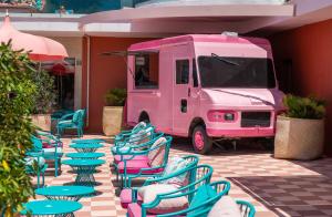 un camión de comida rosa estacionado con sillas y mesas en NYX Hotel Ibiza by Leonardo Hotels-Adults Only en Bahía de San Antonio