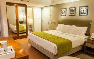a bedroom with a large bed and a bathroom at Quality Porto Alegre in Porto Alegre