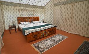1 dormitorio con cama de madera en una habitación con alfombra en Shivadya Camps MAHAKUMBH Mela, en Allahābād