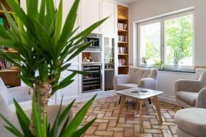 ein Wohnzimmer mit Stühlen, einem Tisch und einer Pflanze in der Unterkunft Apartamenty Panorama Szczawnica in Szczawnica