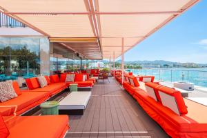 a deck on a cruise ship with orange benches at NYX Hotel Ibiza by Leonardo Hotels-Adults Only in San Antonio Bay +41 photos