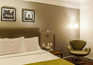 阿雷格里港的住宿－阿雷格里港品質酒店，配有一张床和一把椅子的酒店客房