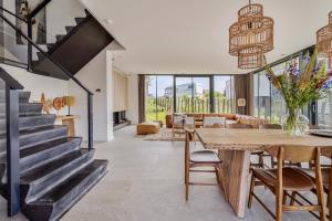a dining room and living room with a table and chairs at Lake House with dock at Lake Veere, Zeeland in Arnemuiden