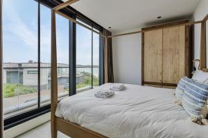 een slaapkamer met een bed en een groot raam bij Lake House with dock at Lake Veere, Zeeland in Arnemuiden