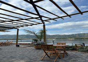 a patio with chairs and a table and a lake at Veneto Village - Vista al Lago - 10 minutos a Carlos Paz in Villa Parque Siquiman