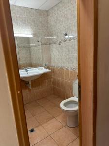 a bathroom with a toilet and a sink at Парк-хотел РИВА in Golden Sands