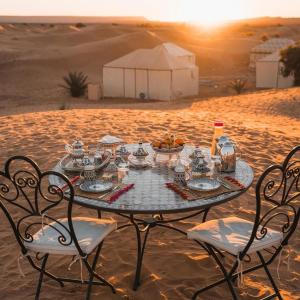Una mesa en medio del desierto con una comida en ella en Merzouga Family Camp, en Merzouga