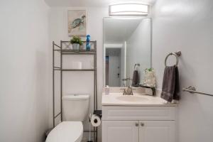 W łazience znajduje się toaleta, umywalka i lustro. w obiekcie Ocean Reserve Condominium w Miami Beach