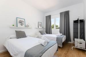 a bedroom with two beds and a window at Port Apartments in Port d'Alcudia
