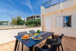 a blue table with food on a balcony with chairs at Port Apartments in Port d'Alcudia