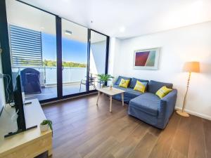 悉尼Relaxing 1BR w Pools & SPA, Gym in Olympic Park的带沙发和桌子的客厅