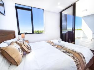 悉尼Relaxing 1BR w Pools & SPA, Gym in Olympic Park的一间带大床和大窗户的卧室