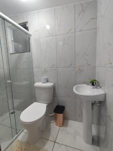 a white bathroom with a toilet and a sink at Residencial 7 Mares in Rio das Ostras +16 photos