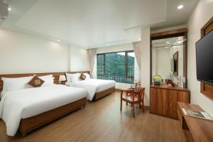 カットバ島にあるDUNG LAI HOTEL 173のベッド2台、薄型テレビが備わるホテルルームです。
