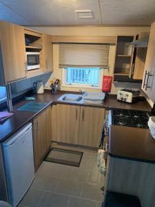 a small kitchen with a sink and a stove at Keeonah 220 Kestrel Close in Saltfleet +6 photos