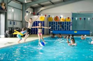 a group of children playing in a swimming pool at MOONSTONE Lymington in Leysdown-on-Sea