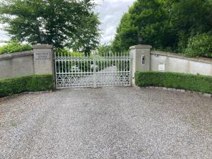 a white gate with a dog behind it at Ballybur Lodge Mews 2 in Kilkenny