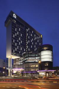 a large building with a clock on it at night at Park Hotel Alexandra in Singapore