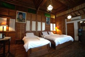 2 Betten in einem Zimmer mit Holzwänden in der Unterkunft Villa Sarimbit in Timuran