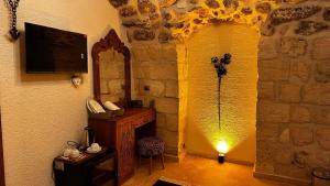 a room with a lamp and a stone wall at Seyr-i asur in Midyat