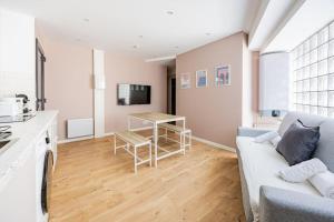 a living room with a couch and a table at Charme Parisien 6 Personnes, 2 chambres, 19ème in Paris