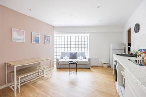 a white living room with a bed in the background at Charme Parisien 6 Personnes, 2 chambres, 19ème in Paris