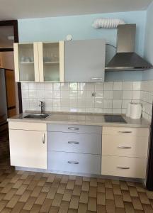 a kitchen with white cabinets and a sink at Apartma Marjeta in Bovec