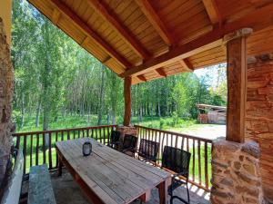 a porch with a wooden table and chairs on a deck at Casas rurales Villa la Roza in La Utrera