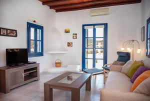 a living room with a couch and a tv at Villa Cyclades Naxos in Naxos Chora
