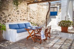 a patio with a couch and a table and chairs at Villa Cyclades Naxos in Naxos Chora