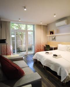 ein Hotelzimmer mit einem Bett und einem Sofa in der Unterkunft Laanhof Studios in Stellenbosch