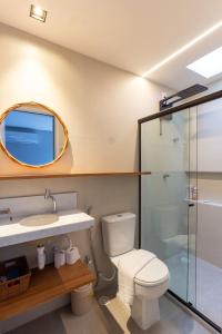 a bathroom with a toilet and a sink and a mirror at Milagres - Naluum Residence in Passo de Camarajibe