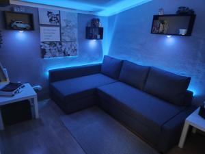 a blue living room with a couch and a table at Domov Carlotka in Bratislava