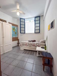 a bedroom with a bed and a window and a table at Casa Vix - Centro Histórico in Vitória